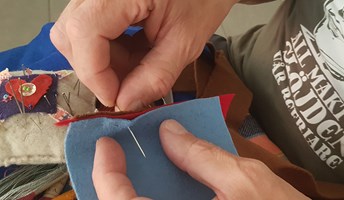 Händer som broderar