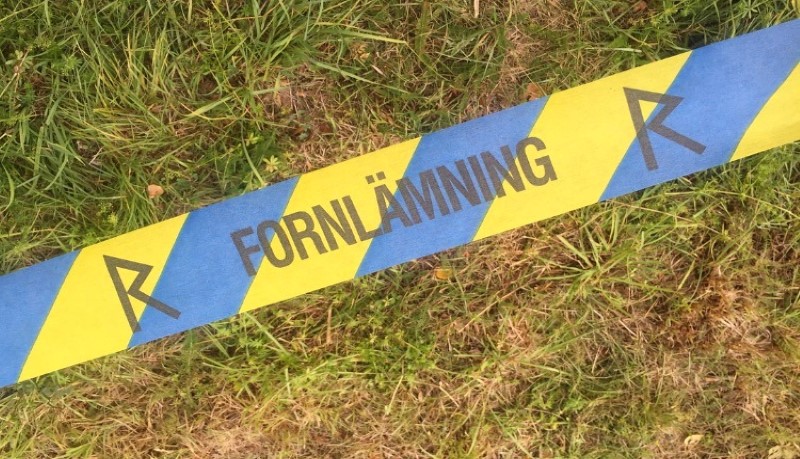 närbild av avspärrningstape med texten fornlämning
