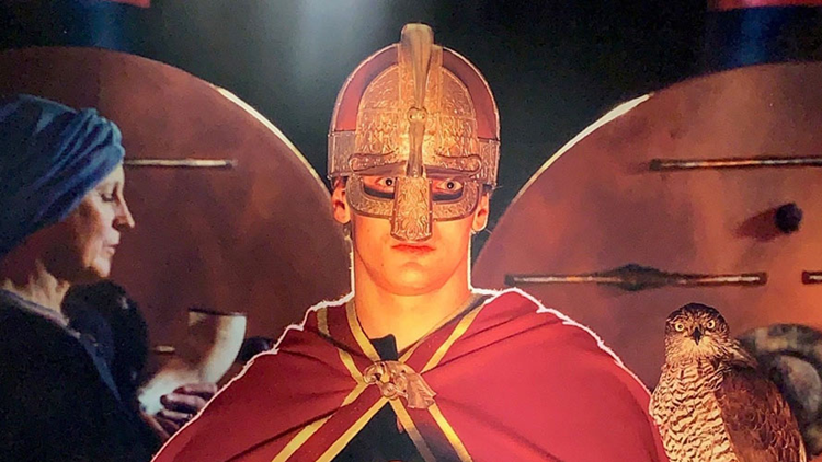 Kung med hjälm och kvinna i bakgrunden