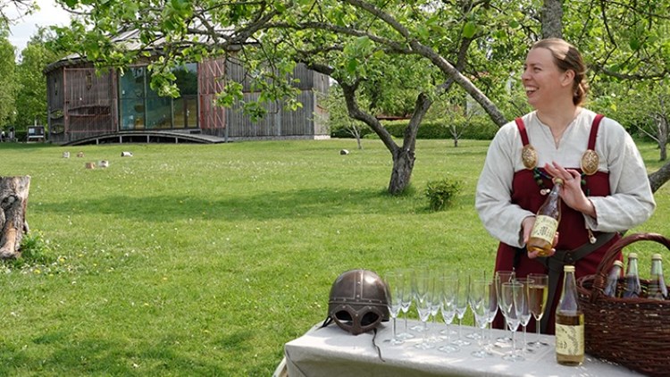 Kvinna i vikingadräkt serverar mjöd