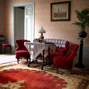 Ett gammaldags finare vardagsrum med möbler från 1800-talet.